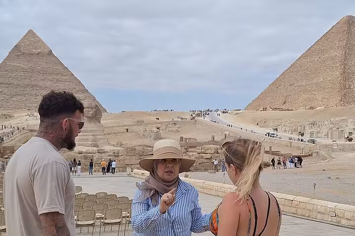 Tour guide explaining the history of the Pyramids of Giza to tourists during a private tour in Egypt.