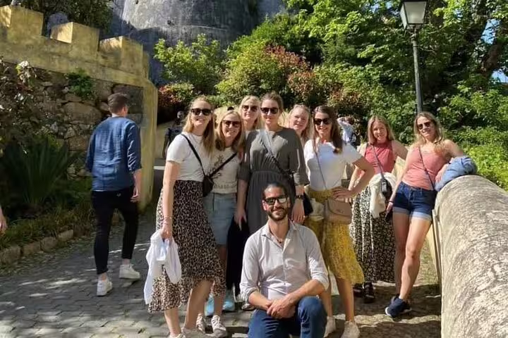 Group of tourists enjoying a sunny day on a private tour of Sintra, exploring the Palaces of Pena and Regaleira from Lisbon.