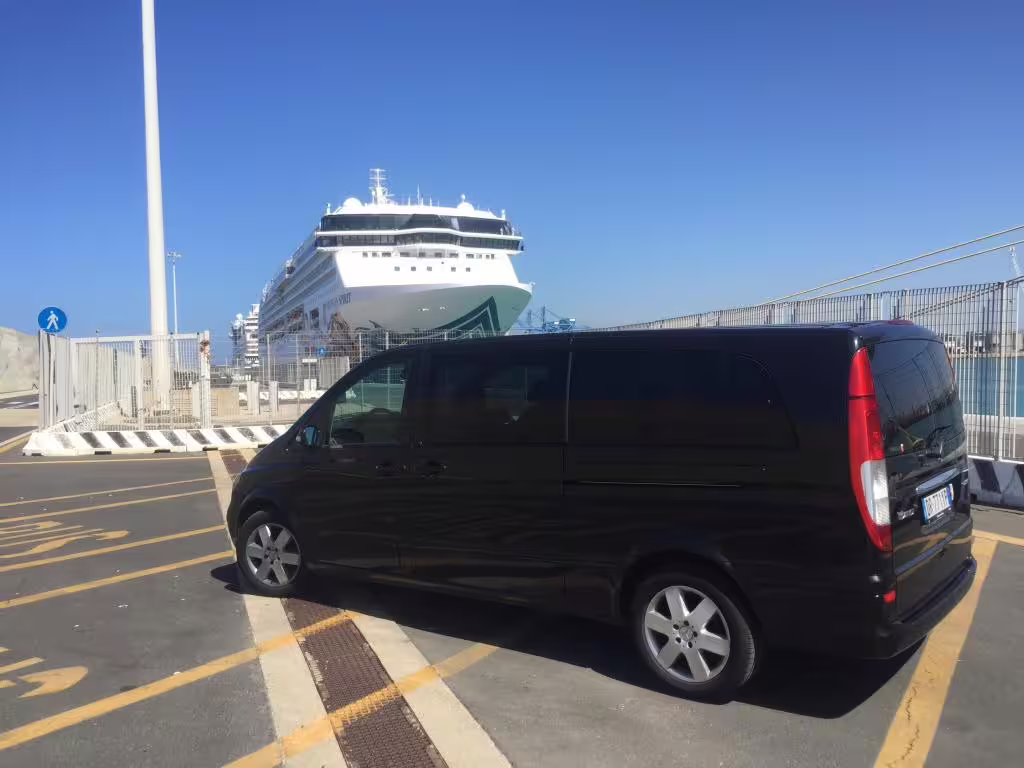 Black minivan waiting beside a docked cruise ship at Civitavecchia Port for private transfer to Fiumicino Airport