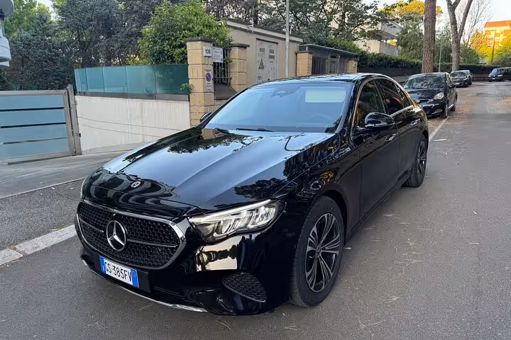 Luxurious black sedan on a quiet street, representing premium private transfer service to Rome.