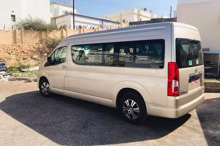 Comfortable beige minivan ideal for private transfer service between Dubai and Muscat, ensuring a smooth journey.