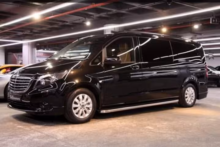 Spacious black van for comfortable private transfers from Fiumicino Airport to Rome, parked indoors.