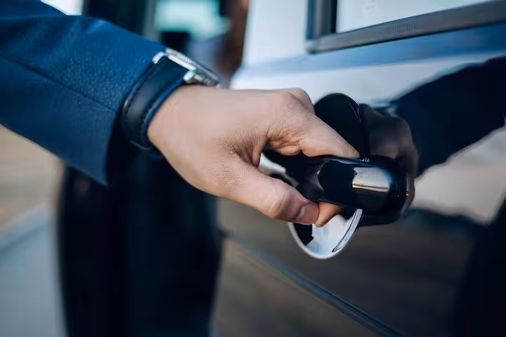 Driver opening car door for private transfer from Hurghada to Aswan, comfortable hotel pickup service in Egypt