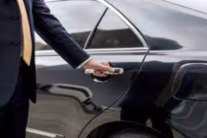 Chauffeur opening sedan door for private transfer from Marsa Alam to Hurghada, Egypt with meet and greet