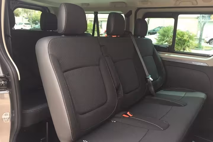 Spacious black leather seats inside private transfer van from Marseille to Nîmes, comfortable ride