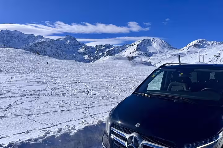 Private transfer vehicle in snowy alpine landscape near St. Moritz, showcasing scenic winter travel from Milan.