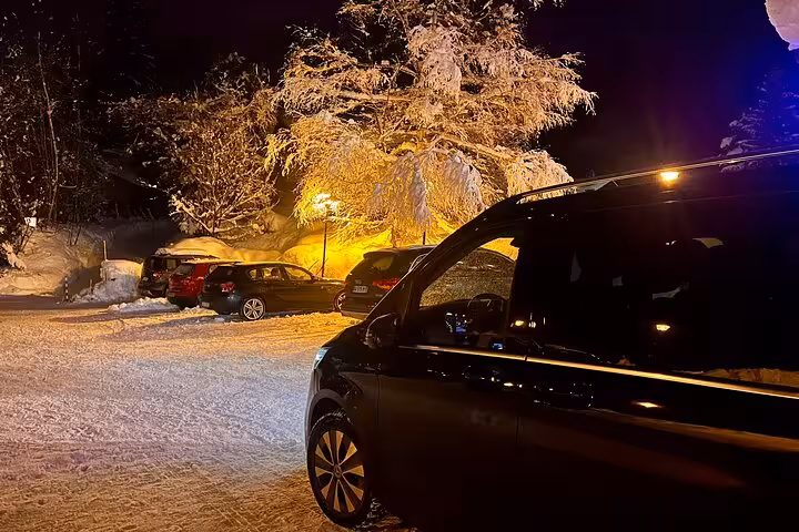 Luxurious car parked at night in snowy landscape, highlighting private transfer from Milan to Zermatt Tasch.