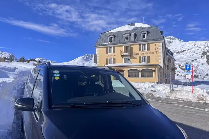 Private transfer vehicle in front of snow-covered hotel on Milan to Zermatt Tasch journey.