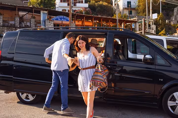 Happy travelers using private transfer service from Naples to Sorrento, enjoying seamless luxury transport.