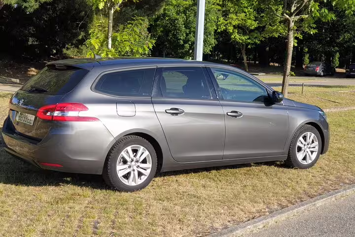 Luxurious private transfer vehicle in Porto for seamless travel to Santiago de Compostela, parked on a grassy area.