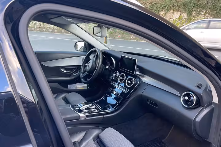 Luxurious black car interior for private transfer from Rome to Amalfi Coast with modern amenities and comfort.