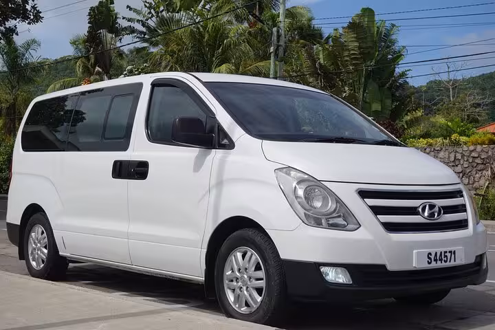White transfer van parked in Seychelles, ideal for private transport with scenic tropical backdrop and modern amenities.