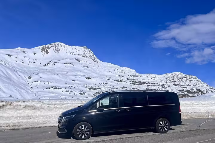 Black private transfer vehicle against snowy Alpine backdrop on Milan to Zermatt Tasch route.