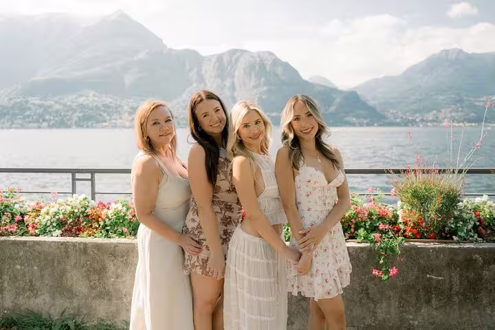 Friends pose by Lake Como waterfront with mountains, captured on a private travel photographer tour in Italy