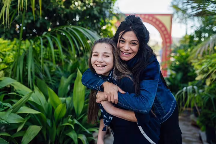 Two smiling people enjoying a lush garden backdrop during a private travel photographer tour in Nice.
