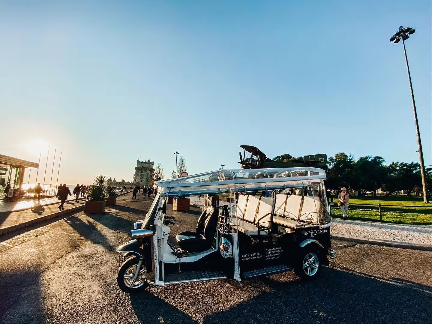 Sunset view of a tuk tuk near Lisbon's famous Belém Tower on a private 4-hour city tour with a local guide.