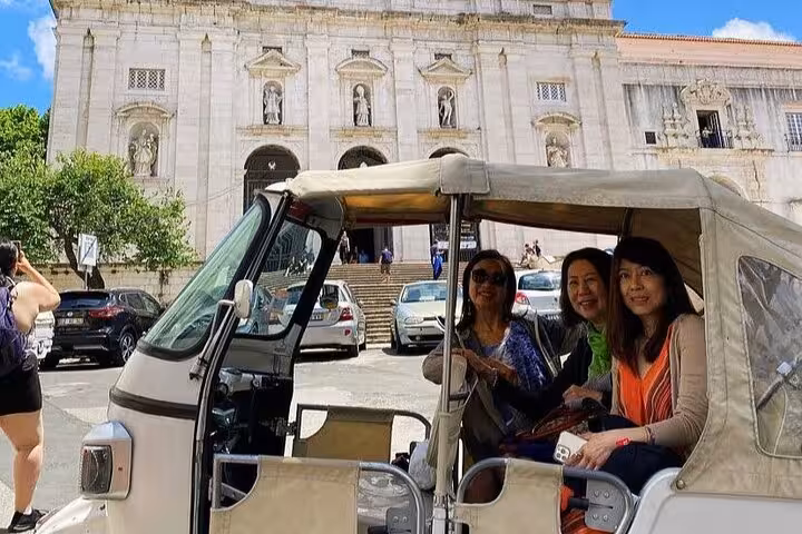 Guests riding tuk tuk outside Lisbon Cathedral Sé, private 2-hour historic Lisbon tuk tuk sightseeing tour