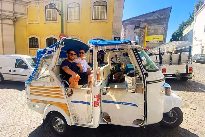 Guests riding a private tuk tuk in Lisbon city center, ideal for a 4-hour sightseeing tour with local guide