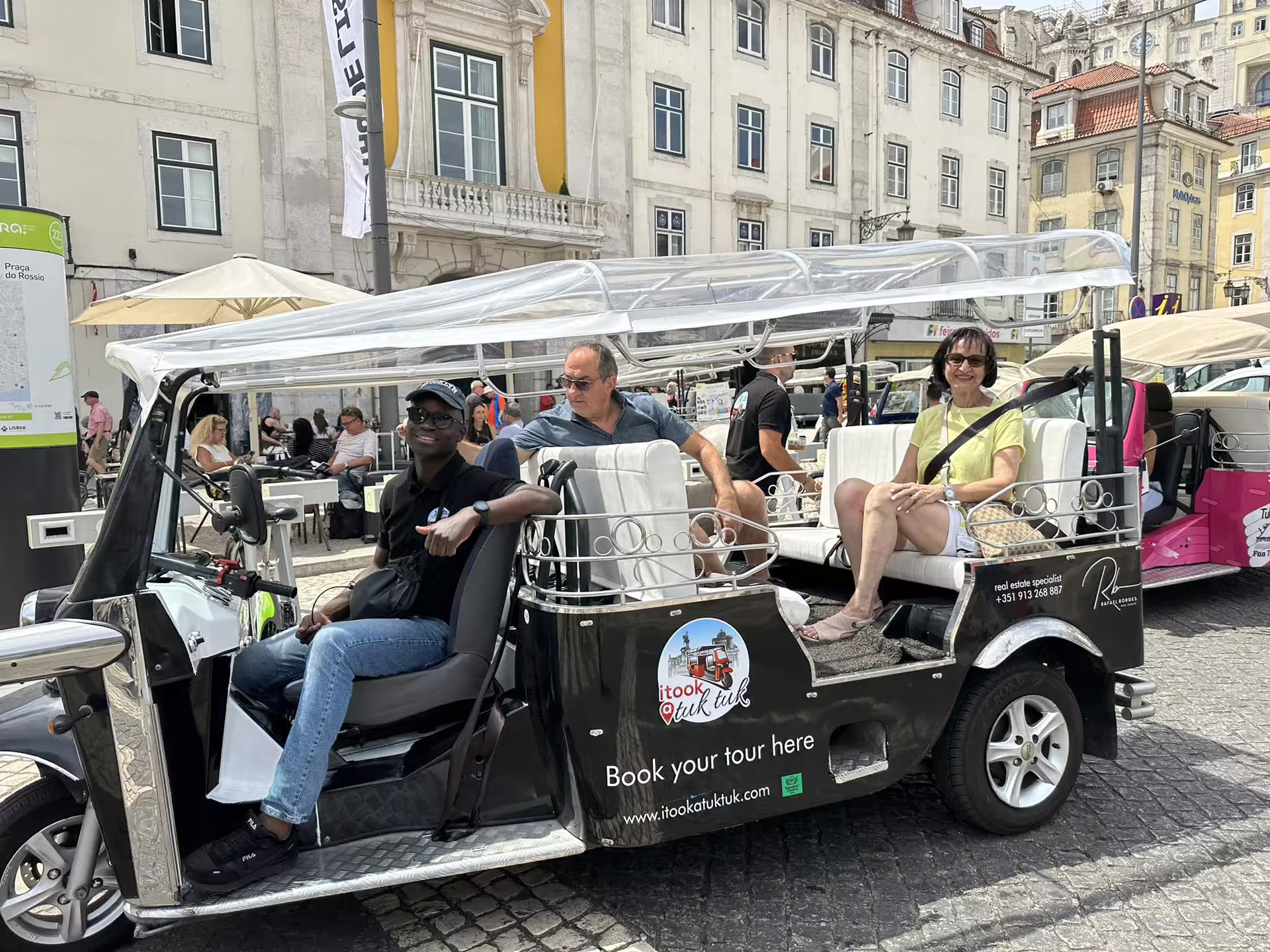 Visitors enjoying a ride in a modern tuk tuk during a private tour through the charming streets of Lisbon.