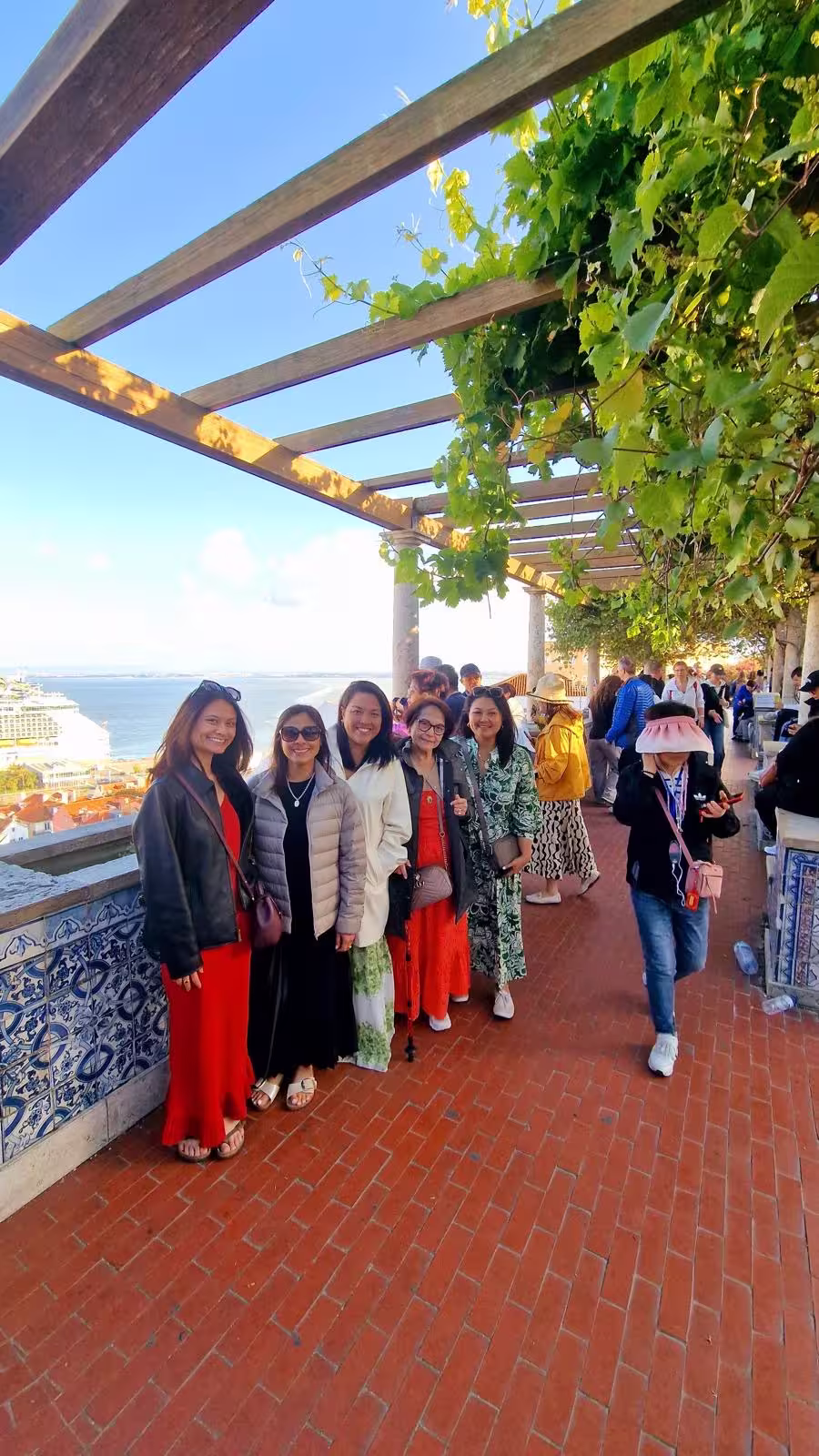 Group of tourists enjoying scenic views from a Lisbon terrace, perfect for a vibrant private walking tour experience.