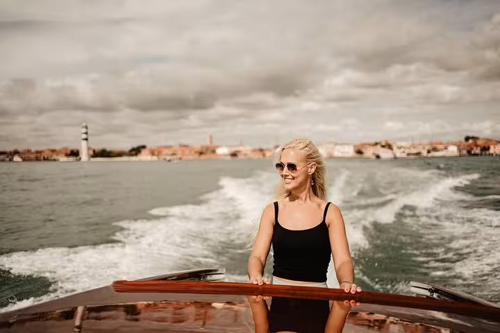 Woman enjoying a private water taxi ride in Venice with stunning views and a professional photographer.