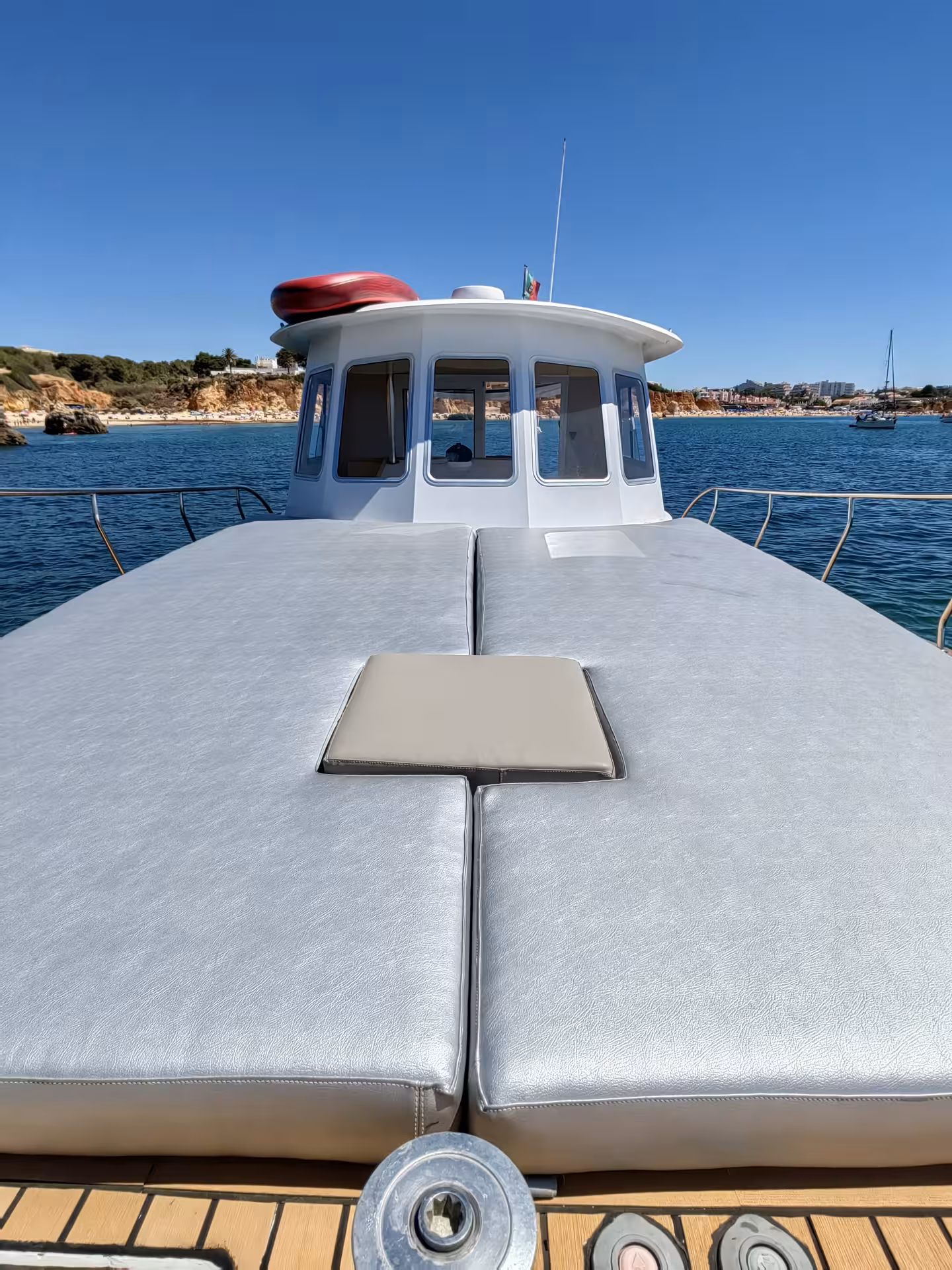 Spacious yacht deck with sun loungers offering panoramic ocean views for a serene sunset charter experience.