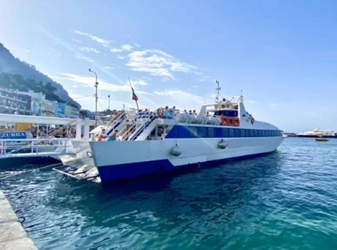 Passenger boat at Procida harbor, starting a scenic boat ride around the island in the Bay of Naples