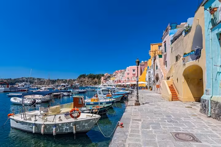 Charming waterfront of Procida island featuring colorful architecture and docked boats, ideal for Naples boat tours.