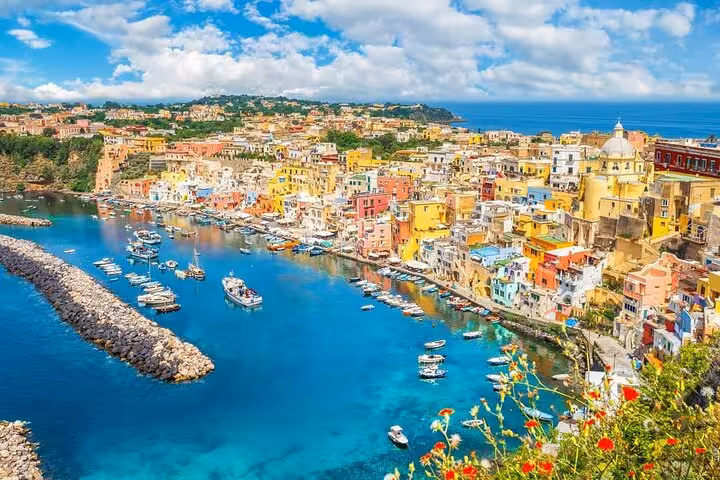 Vibrant Procida island with colorful buildings and boats, seen on a full-day boat tour from Naples.