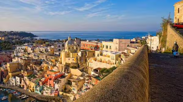 Panoramic view over Procida’s pastel old town and marina toward the Bay of Naples on an Ischia & Procida cruise from Sorrento