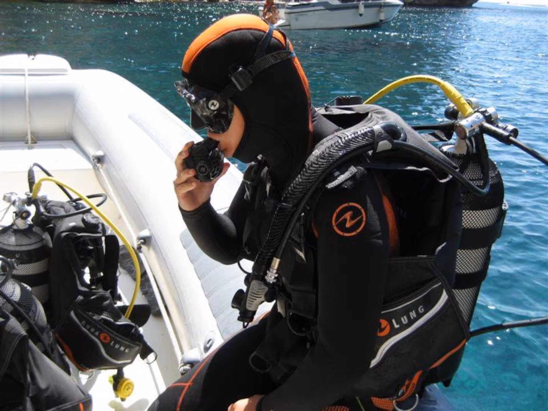 Professional diver gearing up on a boat at Capo Caccia, Alghero for an advanced diving tour.