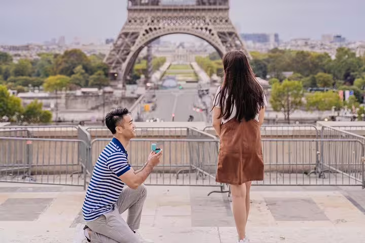 Man kneels with ring box at Trocadéro facing Eiffel Tower, surprise proposal photo shoot in Paris