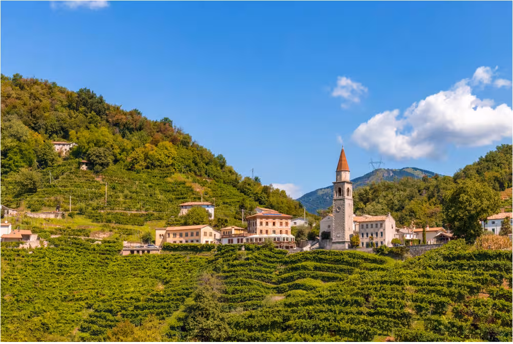Scenic view of Prosecco hills and charming village architecture in Veneto, perfect for a wine tasting tour from Venice.
