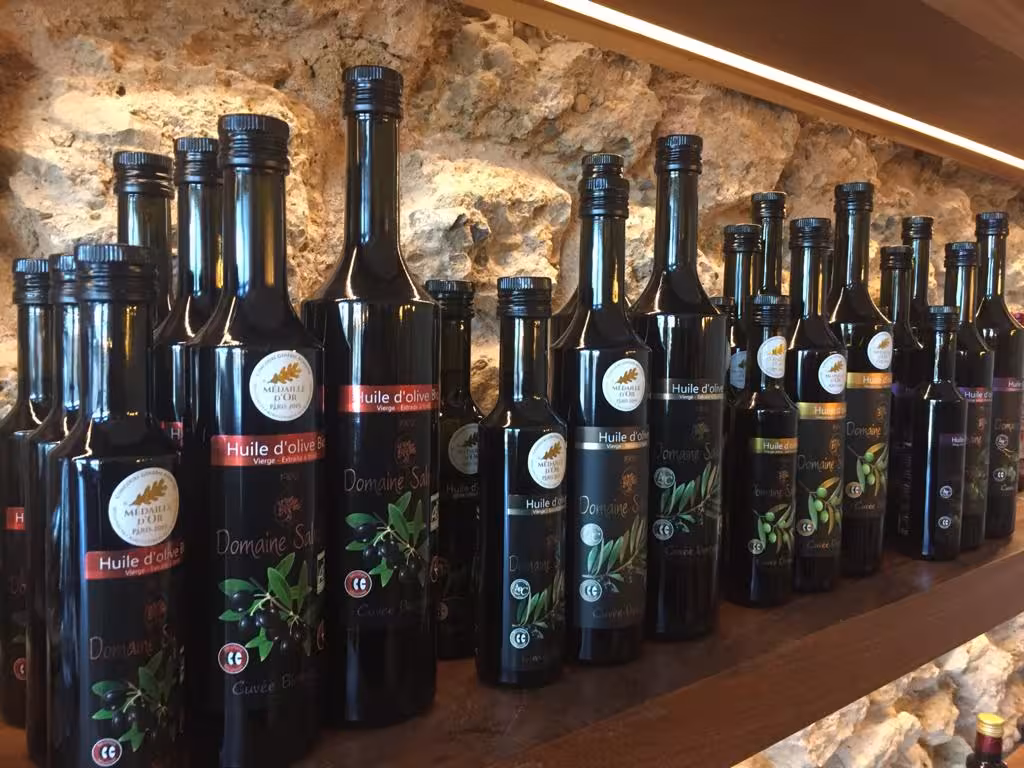 Bottles of Provençal olive oil lined up in a Marseille delicatessen, tasting stop on a guided food tour