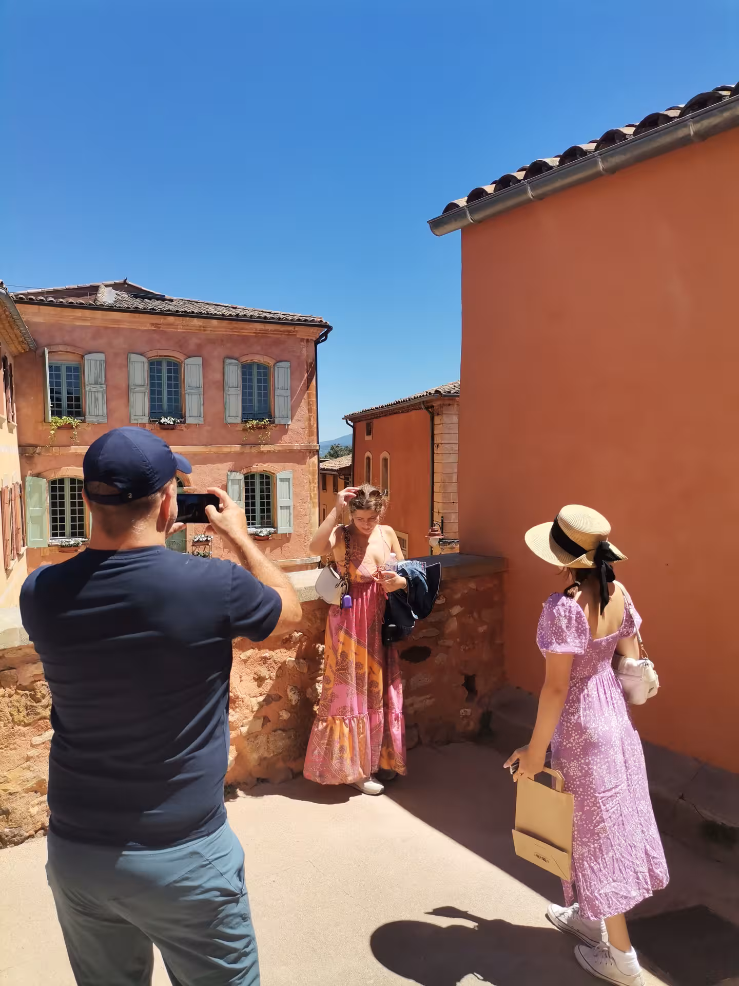 Tour guests photographing in Roussillon ochre village streets during a Provençal Picnic Tour in Provence