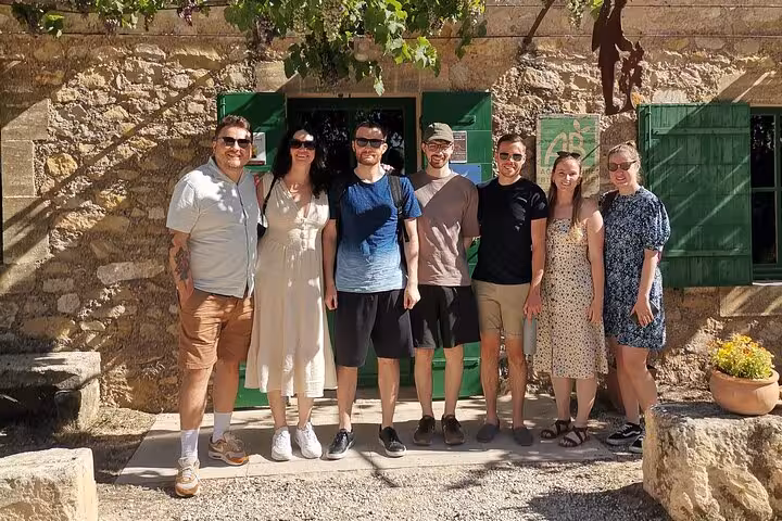 Small group posing at a Provençal stone farmhouse in Saint Rémy de Provence on a guided day tour