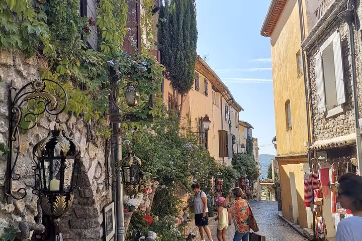 Sunny Provençal village street with shops and flowers, explored via private vehicle with driver in Provence