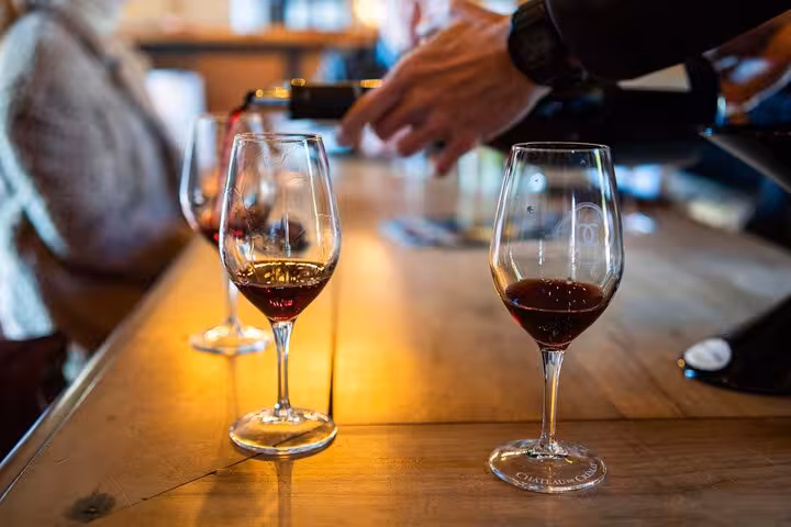 Close-up of red wine being poured into glasses during a Provencal wine tasting session.
