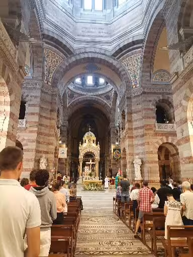 Worshippers inside a historic Provence basilica, highlighting sacred art and Christian heritage on a 14-day tour