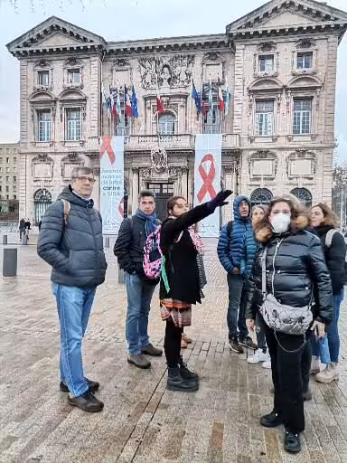 Guided group tour in Avignon square before a grand historic building, exploring Provence Christian culture