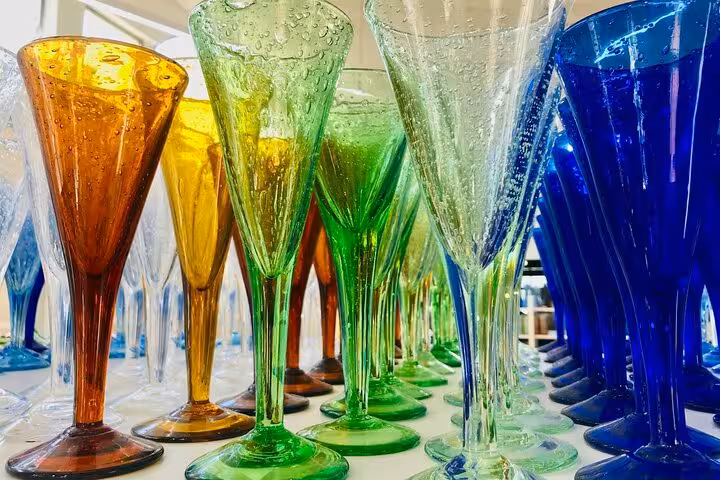 Vibrant collection of handcrafted colorful glassware on display in a Provence countryside village shop.