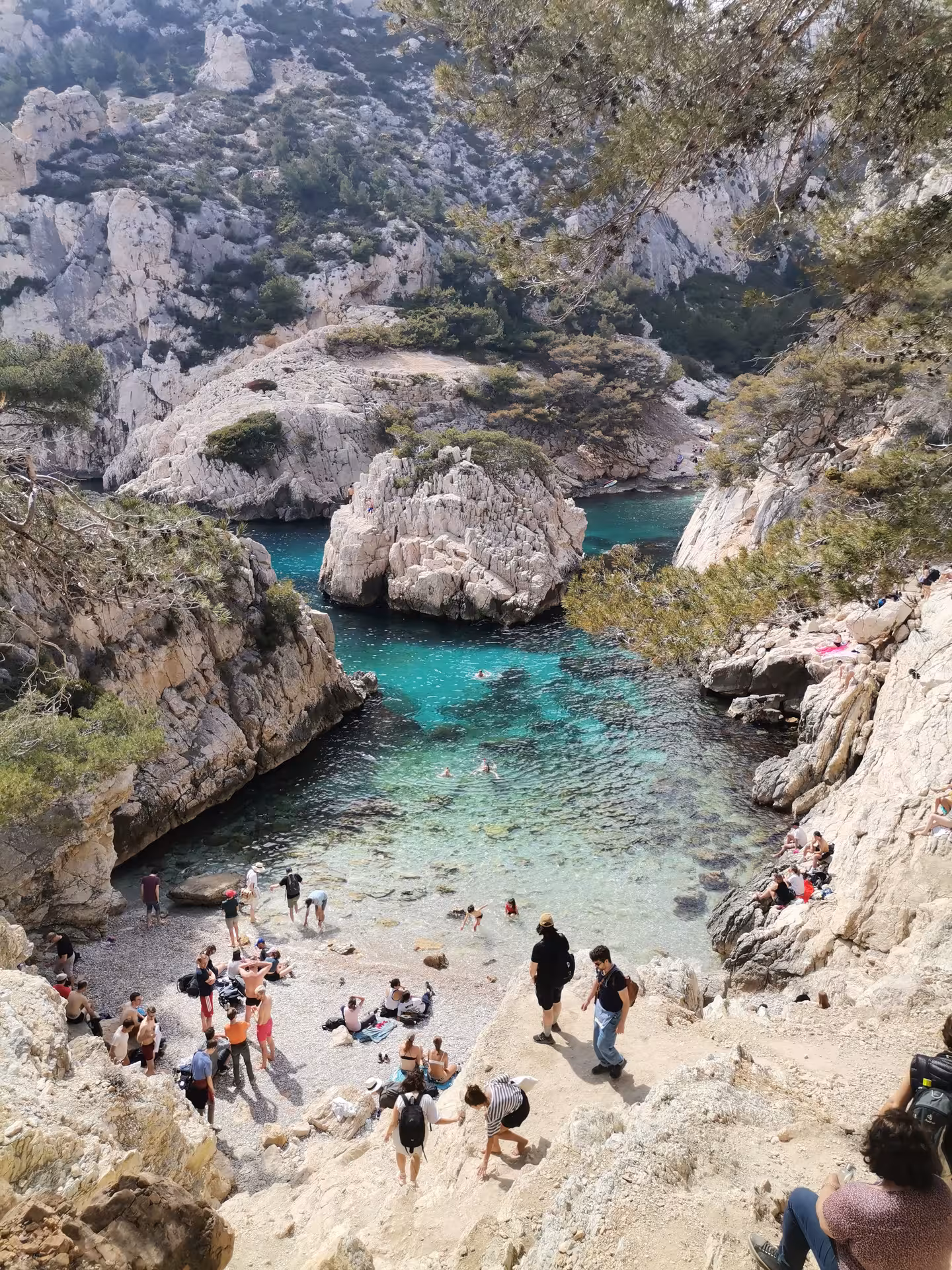 Turquoise Calanques cove near Marseille with hikers and swimmers, coastal trail on Provence hiking getaway