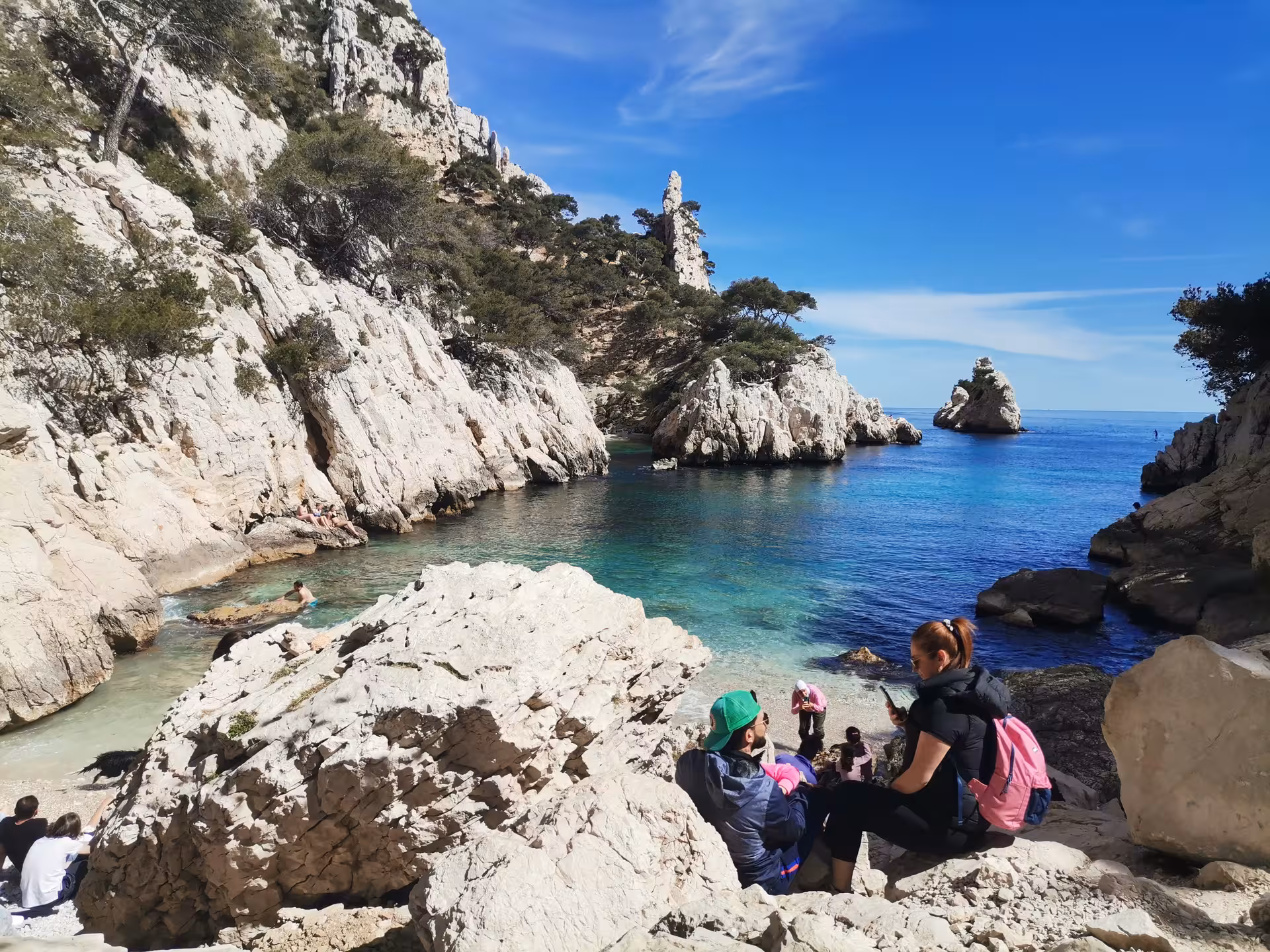 Hikers rest above a turquoise Calanques cove near Marseille on an 11-day Provence hiking getaway