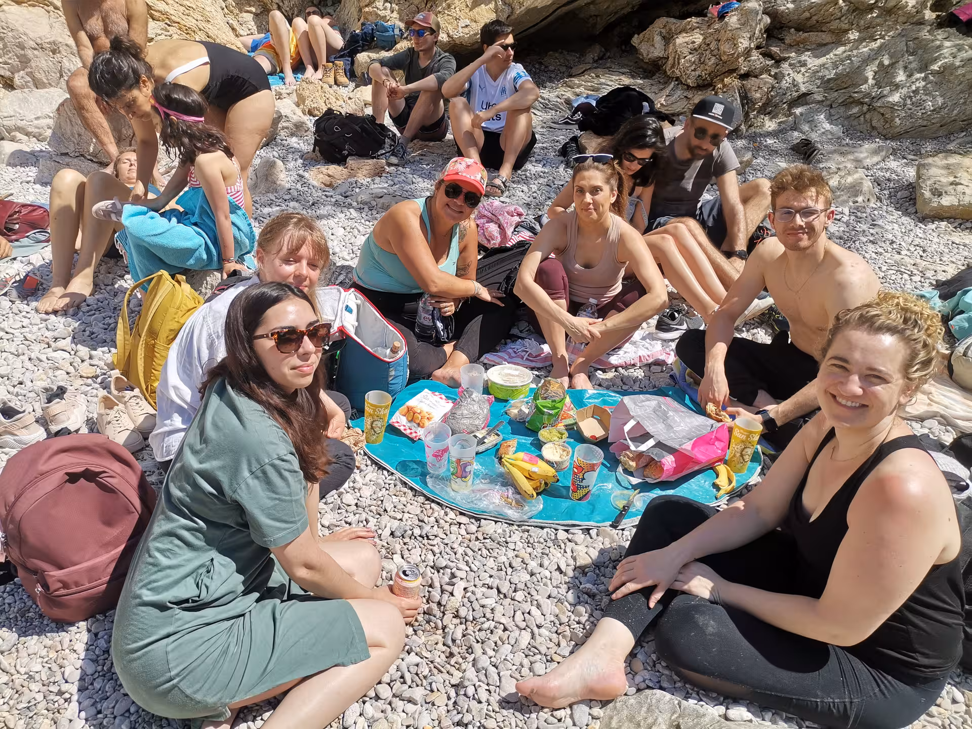Hikers enjoy a picnic on a pebble beach in the Calanques near Marseille during a 14-day Provence hiking tour