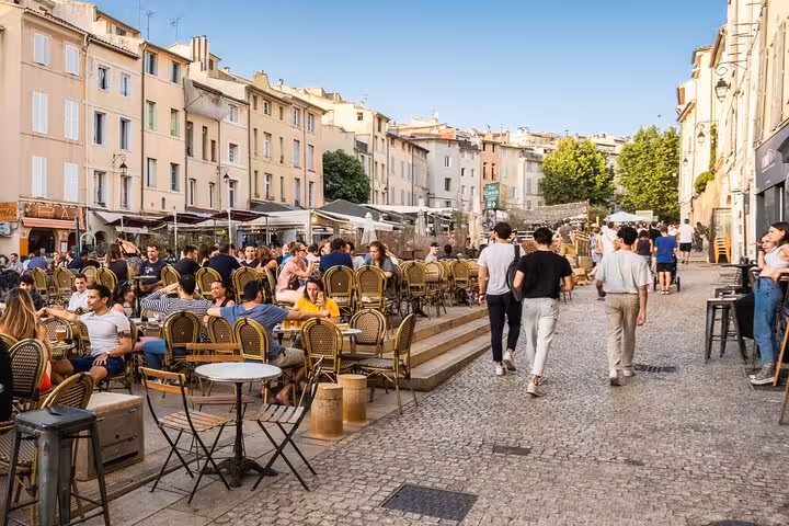 Bustling outdoor cafe scene in Provence, capturing the vibrant atmosphere of a sunny day trip.