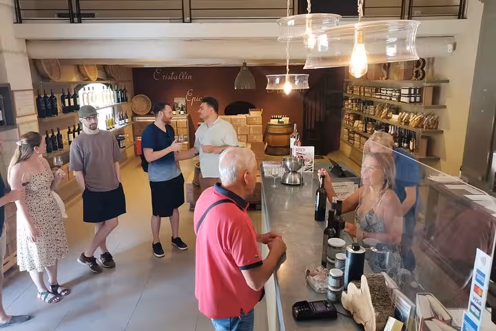 Visitors tasting local Provence wines in a shop, included in Baux and Saint-Rémy de Provence day tour experience