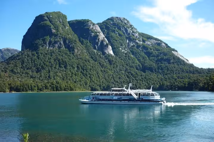Tour boat cruising on Lake Frías against dramatic mountain landscape at Puerto Blest.