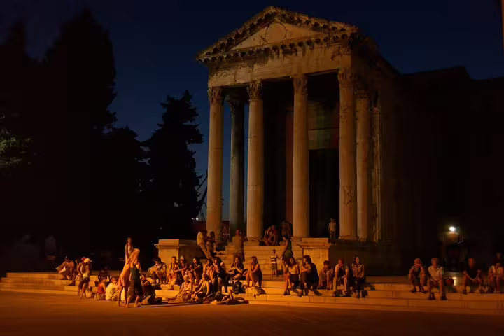 Evening crowd outside a Roman temple near Pula Arena, Croatia, before amphitheater admission ticket entry