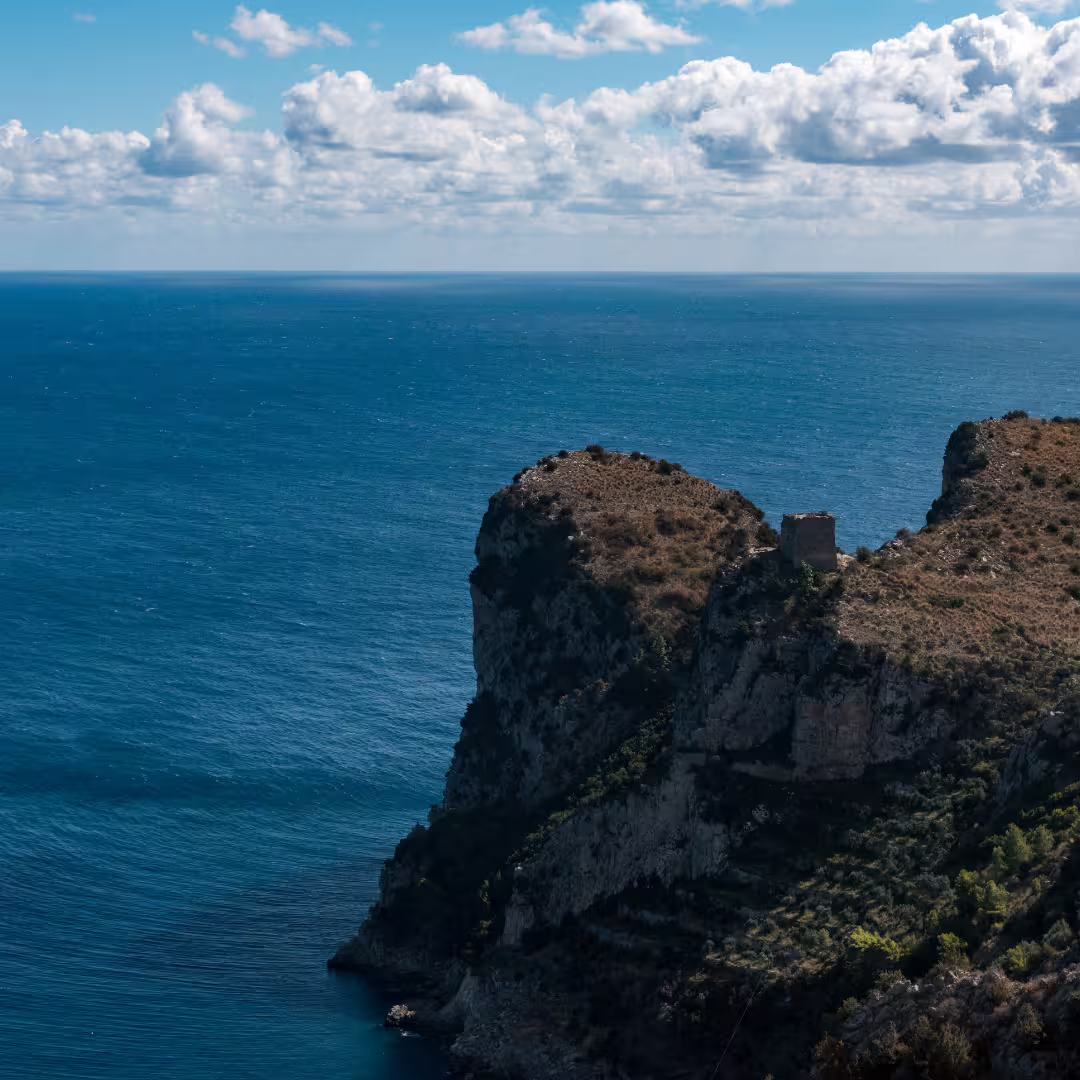 Panoramic view of Punta Campanella cliffs over deep blue Tyrrhenian Sea on trekking weekend from Sorrento, Amalfi Coast