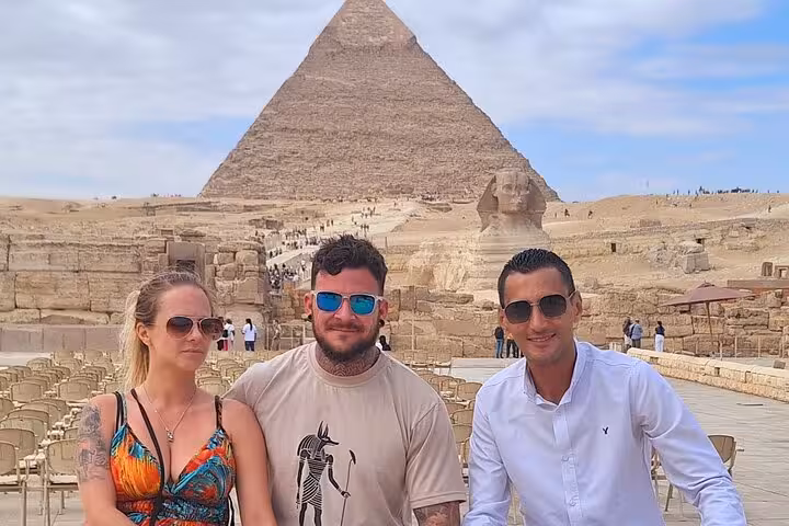 Tourists enjoy a sunny day at the Pyramids of Giza with the Sphinx in the background, showcasing iconic Egyptian landmarks.